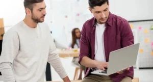 Mężczyzna wprowadzający współpracownika w zagadnienia lean management